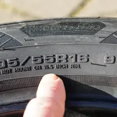 Dedo señala inscripción en neumático: 205/55R16 91V. ¡Cuidado con la caducidad neumáticos!