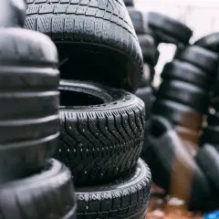 Montón de neumáticos mojados apilados. ¿Cuánto pesa un neumático? La imagen muestra una pila de neumáticos de coche, algunos con clavos para el invierno.