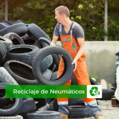 Trabajador gestionando el reciclaje de neumáticos. Montañas de llantas usadas esperan ser procesadas para un futuro más verde.