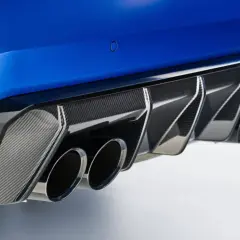 Detalle de escape cuádruple de coche deportivo azul, con difusor de fibra de carbono. Un vistazo a las emisiones de CO2 de los coches.