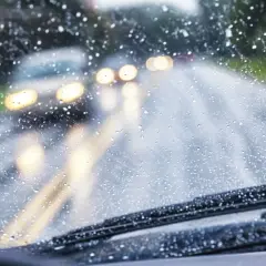 Si conduciendo le sorprende una lluvia torrencial, el parabrisas se llena de gotas. Luces de otros coches se difuminan en la carretera mojada.