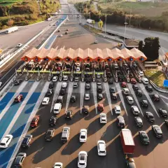 Larga fila de coches en un peaje, creando un gran atasco. Los vehículos esperan pacientemente su turno para pasar.