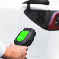 Mano sujetando un cargador de coche eléctrico, listo para conectar. Averigua cuanto cuesta cargar un coche eléctrico en Carrefour.