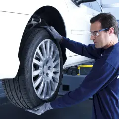 Mecánico revisa un neumático para vulcanizar pinchazo lateral.