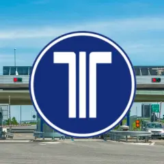 Peaje con señal azul y blanca de "T". Un coche se acerca a pagar con su tarjeta peajes.