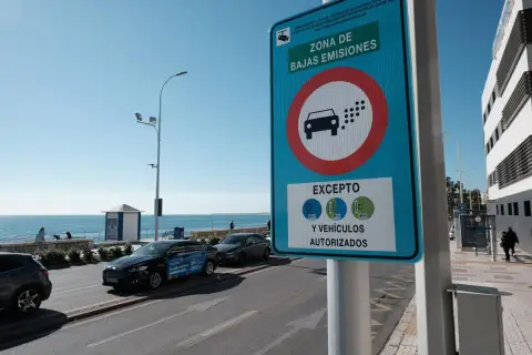 Señal de "Zona de Bajas Emisiones" (ZBE) con un coche y puntos de emisión. Indica excepciones para vehículos con distintivos C, ECO y 0.