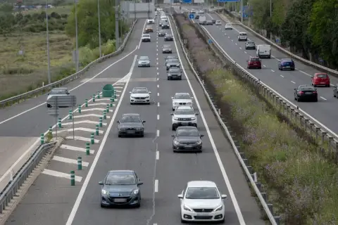 Tráfico en autopista, coches circulando. ¿Cuánto vale el peaje de Madrid? La carretera se ve con vegetación a los lados.
