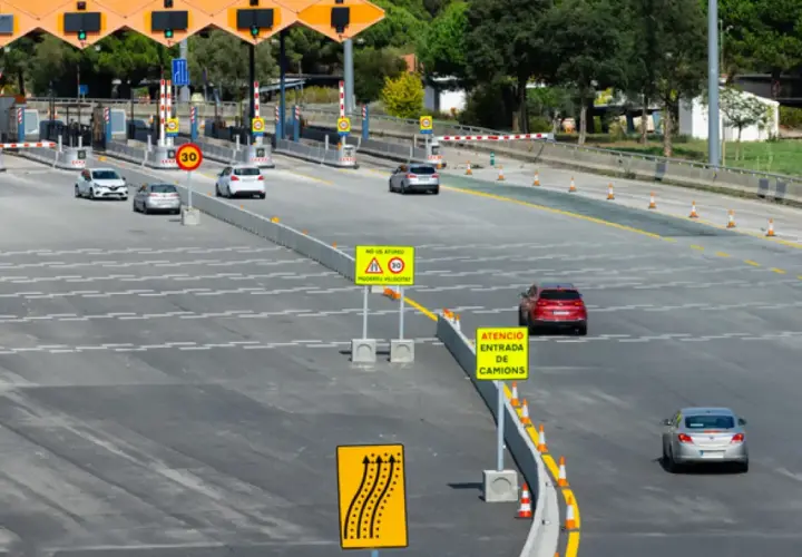 Peaje con carriles de pago y señales de tráfico. El ap-66 precio es visible en una señal.