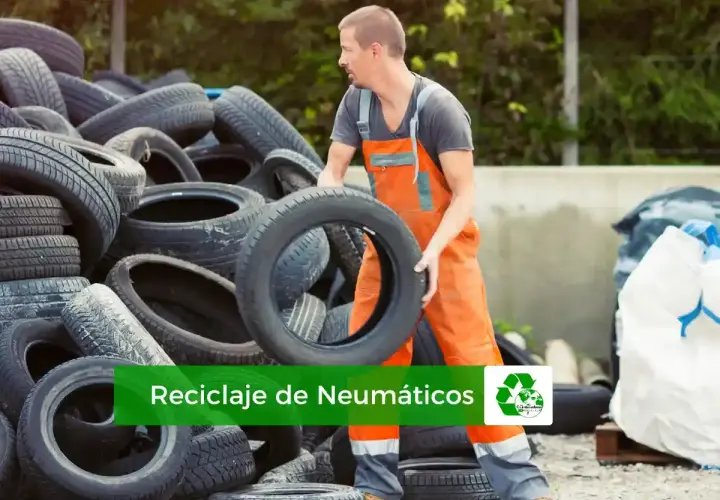 Trabajador gestionando el reciclaje de neumáticos. Montañas de llantas usadas esperan ser procesadas para un futuro más verde.