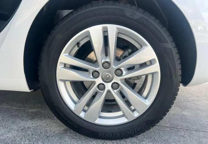 Rueda de Opel Astra con llanta plateada y neumático Bridgestone Turanza. Comprueba la presión de los neumáticos para un viaje seguro.