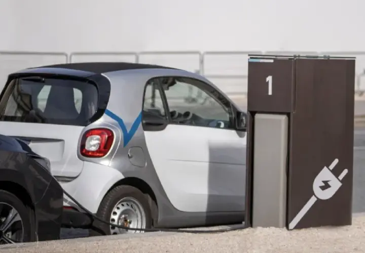 Coche eléctrico blanco conectado a un punto de carga. El tiempo de carga coche eléctrico es eficiente.