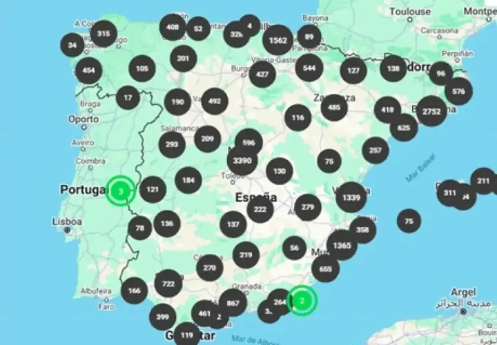 Mapa de España y Portugal con puntos negros y verdes indicando la ubicación y cantidad de estaciones de carga de vehículos eléctricos.