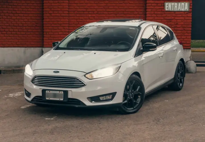 Ford Focus blanco con llantas negras, listo para rodar. La presión de los neumáticos es clave para un viaje seguro.