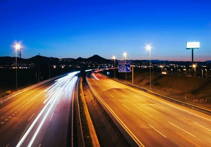 Autopista nocturna con estelas de luz de vehículos, reflejando la **estrategia seguridad vial 2030** para un futuro más seguro.