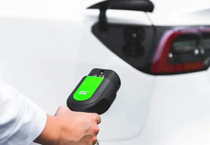 Mano sujetando un cargador de coche eléctrico, listo para conectar. Averigua cuanto cuesta cargar un coche eléctrico en Carrefour.