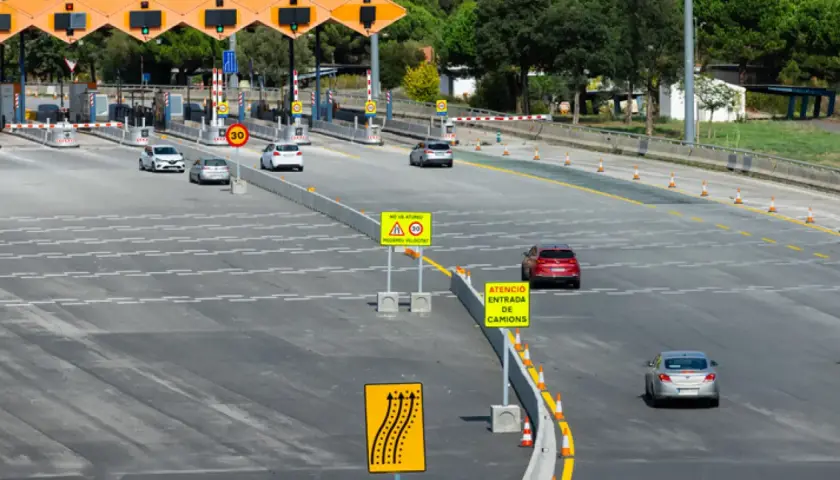 Peaje con carriles de pago y señales de tráfico. El ap-66 precio es visible en una señal.