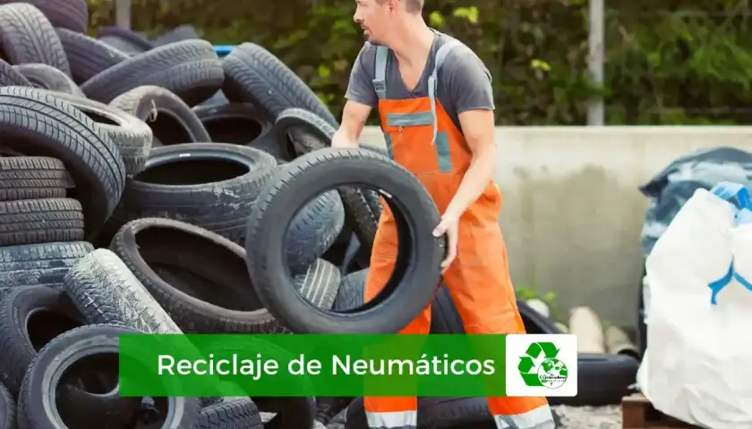 Trabajador gestionando el reciclaje de neumáticos. Montañas de llantas usadas esperan ser procesadas para un futuro más verde.