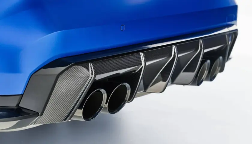 Detalle de escape cuádruple de coche deportivo azul, con difusor de fibra de carbono. Un vistazo a las emisiones de CO2 de los coches.