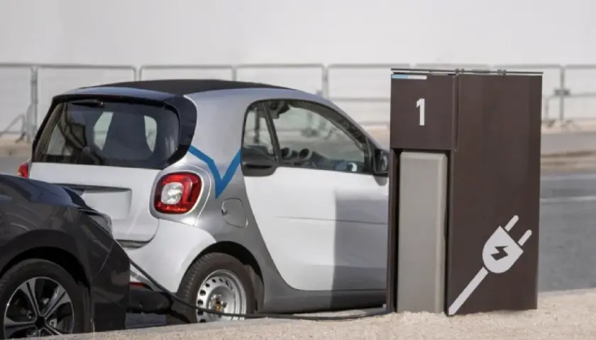 Coche eléctrico blanco conectado a un punto de carga. El tiempo de carga coche eléctrico es eficiente.