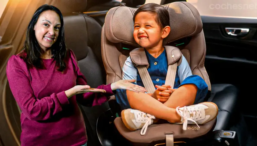 Una mujer sonríe mientras señala a un niño feliz sentado en su silla de coche. ¡Los niños en el coche están seguros y contentos!