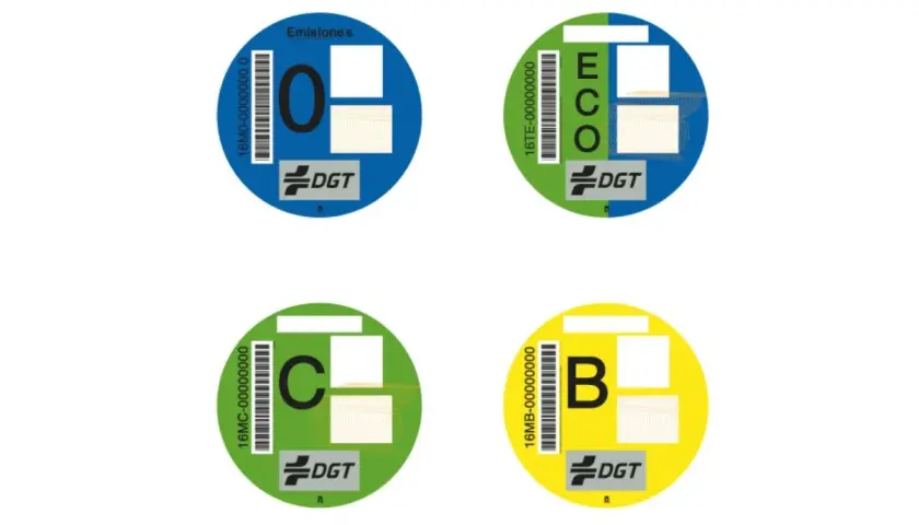 Cuatro etiquetas medioambientales circulares de la DGT: "0" (azul), "ECO" (verde y azul), "C" (verde) y "B" (amarillo).