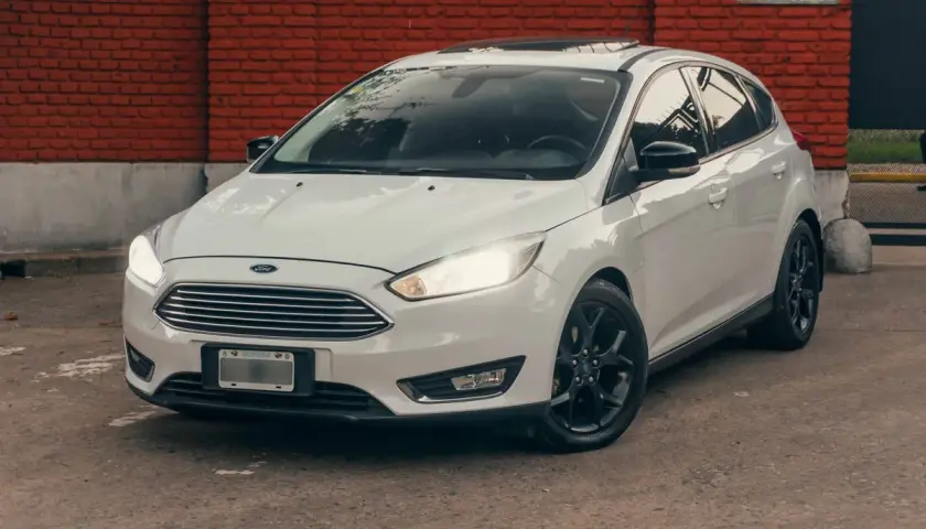 Ford Focus blanco con llantas negras, listo para rodar. La presión de los neumáticos es clave para un viaje seguro.