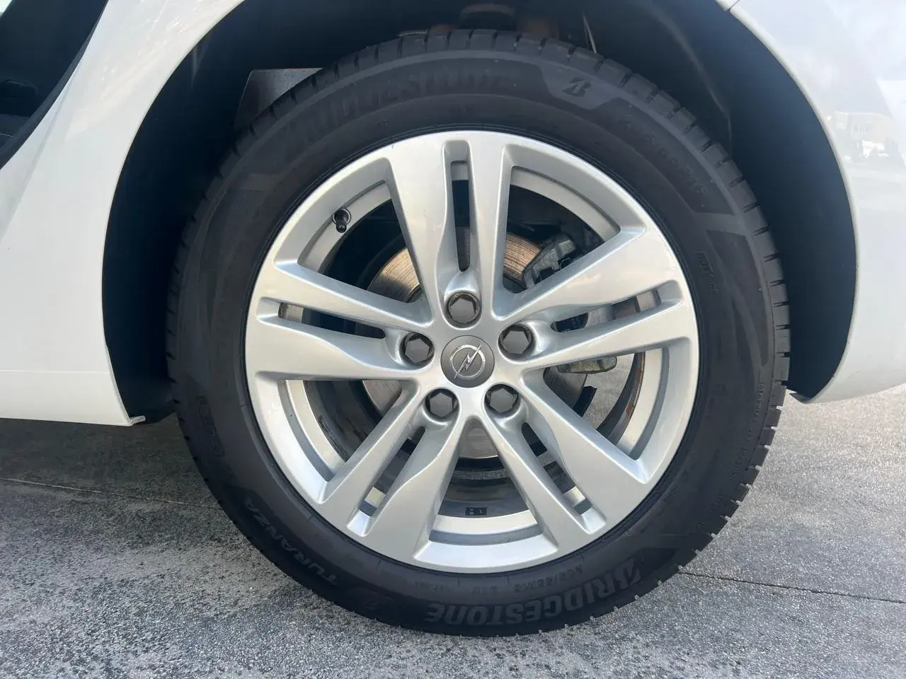 Rueda de Opel Astra con llanta plateada y neumático Bridgestone Turanza. Comprueba la presión de los neumáticos para un viaje seguro.