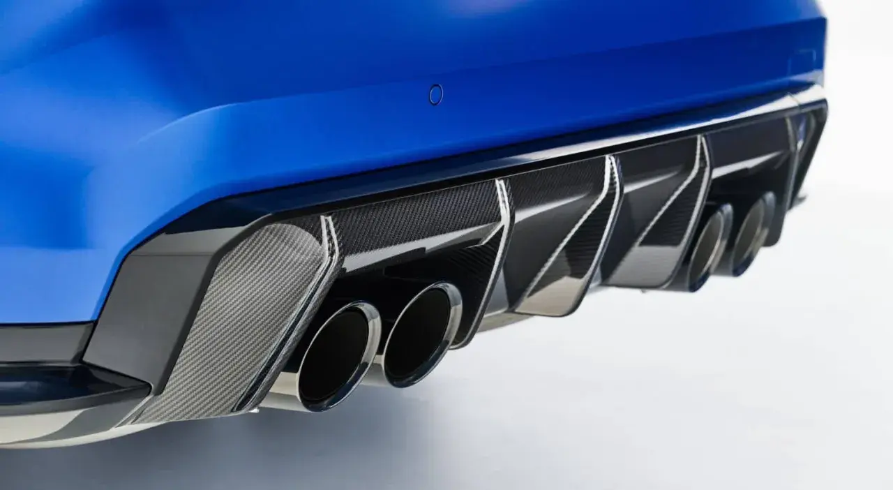 Detalle de escape cuádruple de coche deportivo azul, con difusor de fibra de carbono. Un vistazo a las emisiones de CO2 de los coches.
