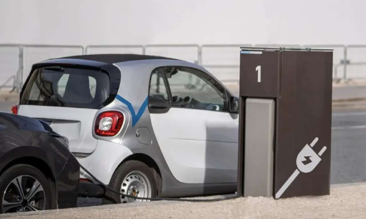 Coche eléctrico blanco conectado a un punto de carga. El tiempo de carga coche eléctrico es eficiente.