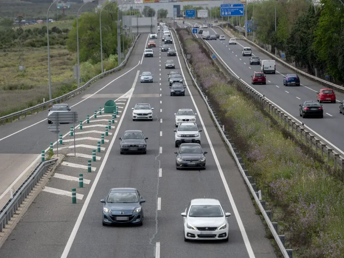 Tráfico en autopista, coches circulando. ¿Cuánto vale el peaje de Madrid? La carretera se ve con vegetación a los lados.