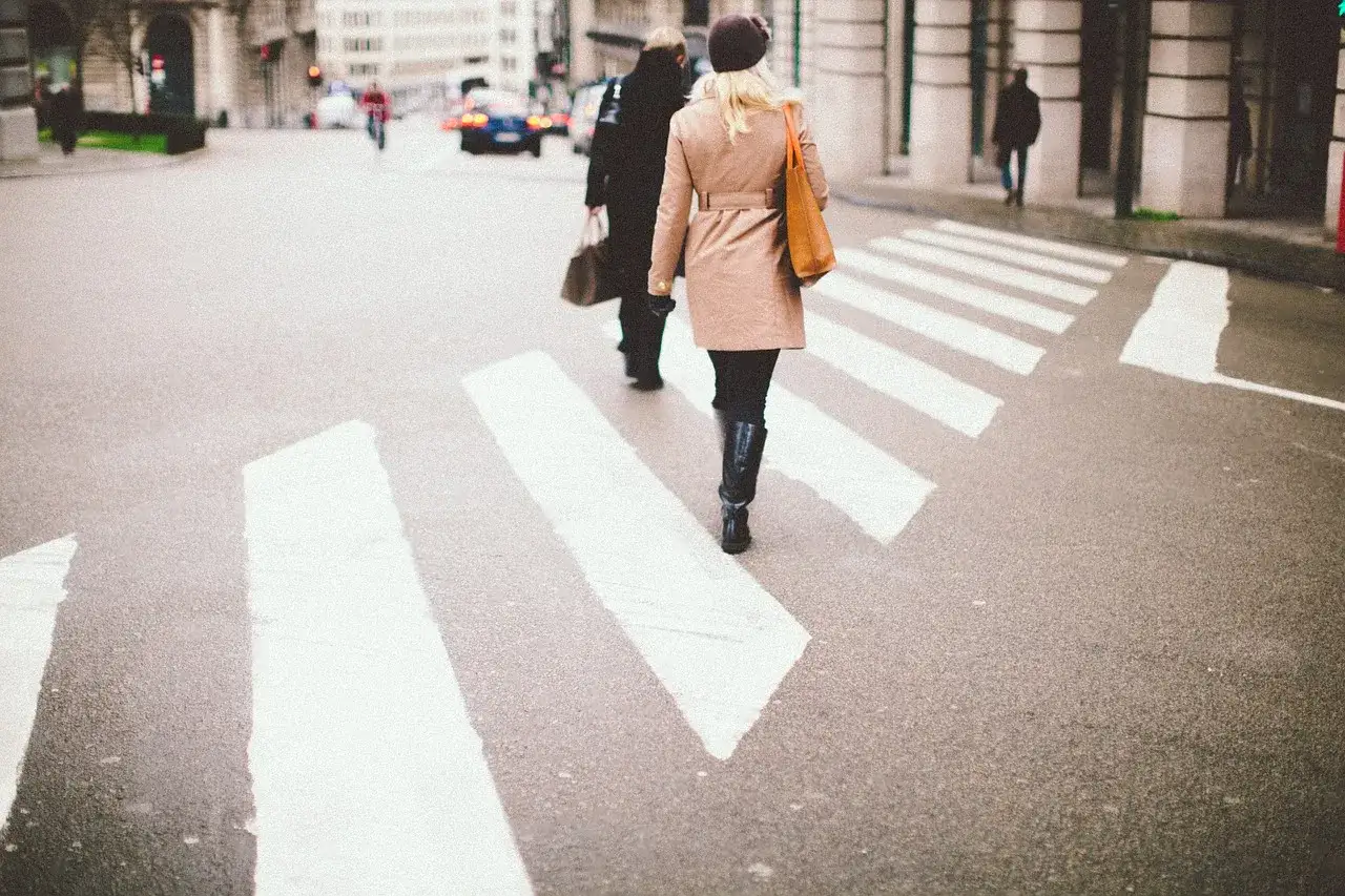 Dos personas cruzan un paso de cebra. Las personas mayores pueden tener problemas como peatones, especialmente en calles concurridas.