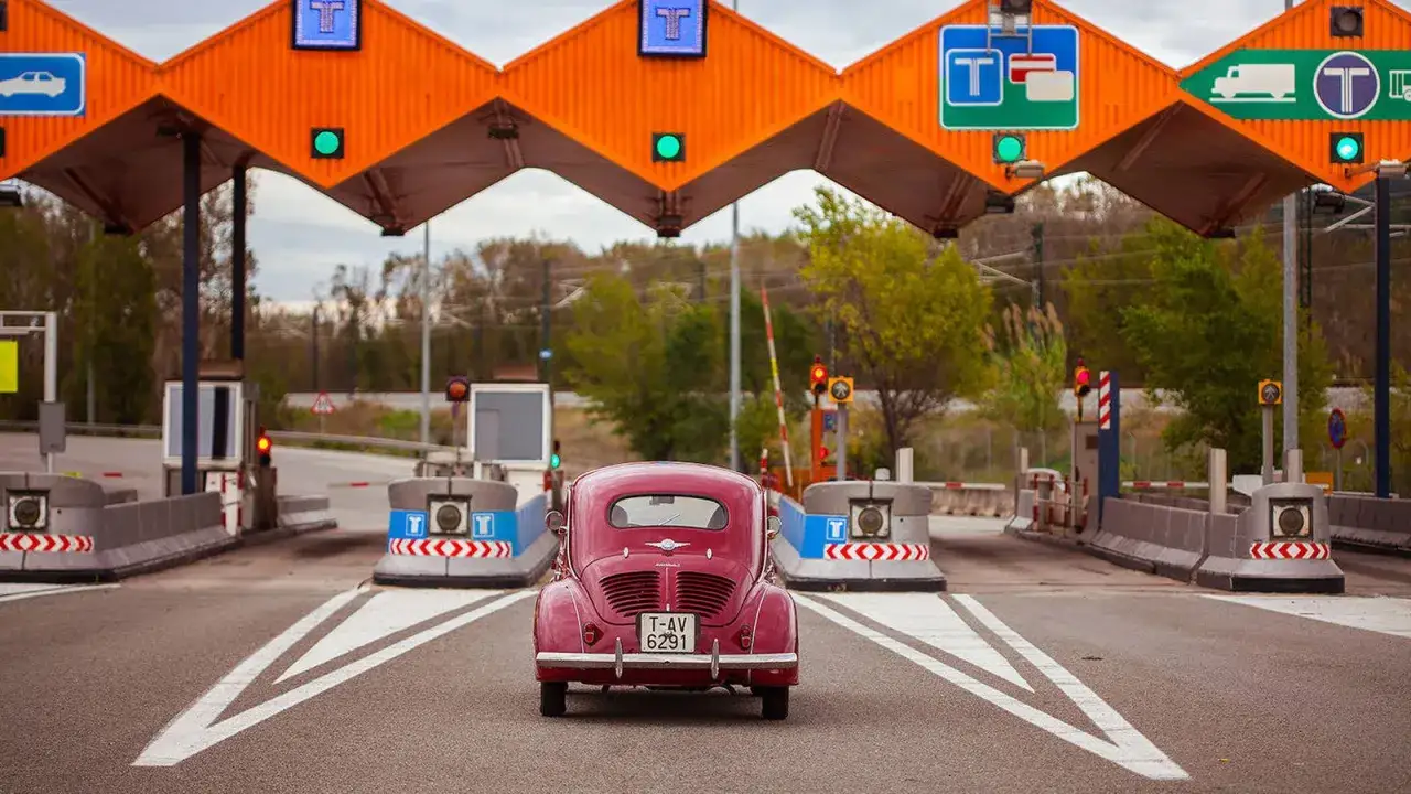 Coche clásico rosa en peaje de autopista, vía T-Unicaja.