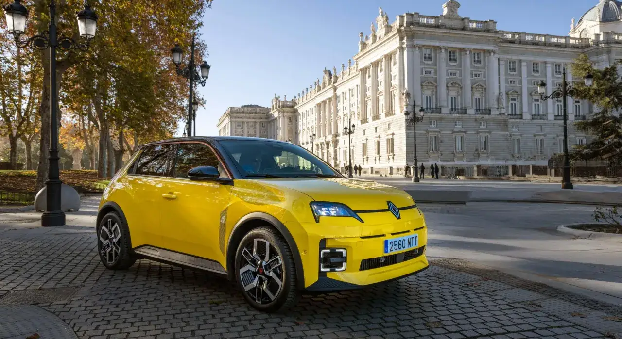 Coche amarillo con etiqueta ECO, listo para circular. Los coches con etiqueta ECO pagan impuesto de circulaci&oacute;n, pero este modelo luce moderno frente a un edificio hist&oacute;rico.
