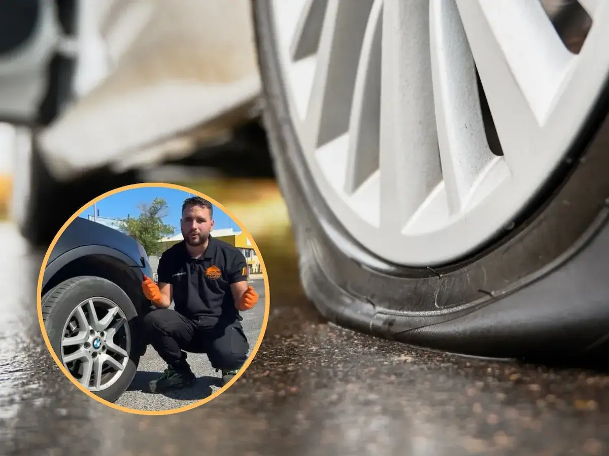 Hombre muestra cómo saber si tengo una rueda pinchada, con un neumático visiblemente desinflado.