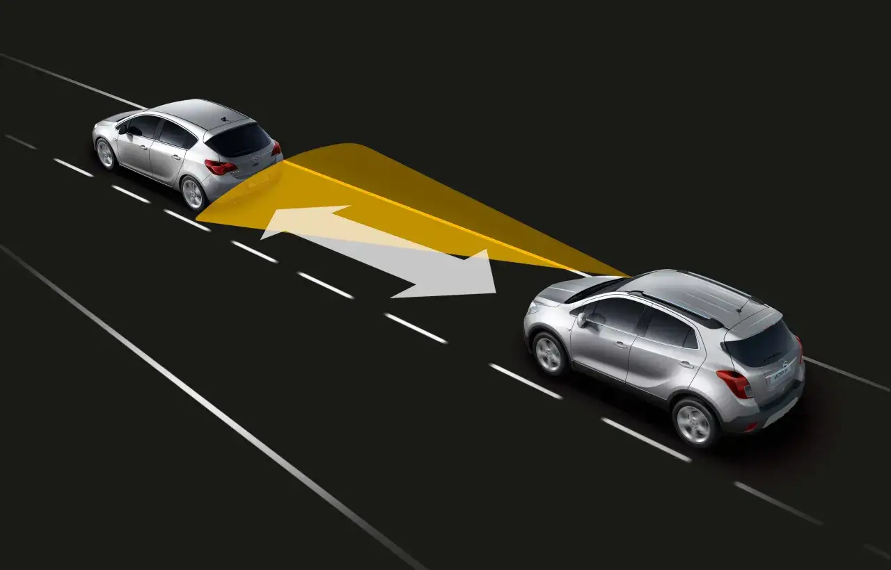 Dos coches plateados en una carretera. El coche de atrás emite un haz amarillo y flechas que indican la distancia de seguridad con el coche de delante.