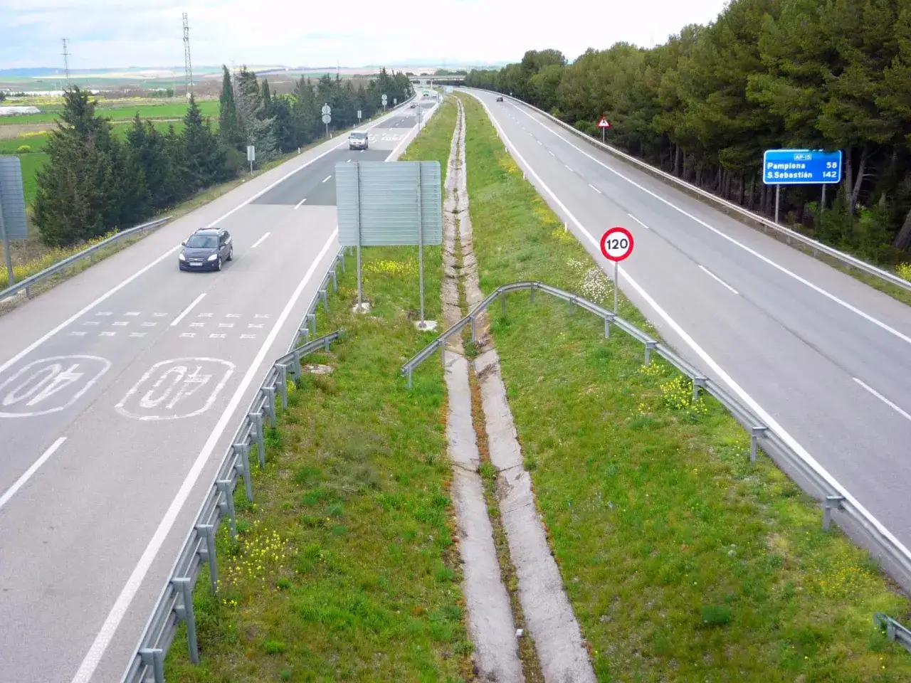 Autopista AP-15 con se&ntilde;al de l&iacute;mite de 120 km/h. Un coche negro circula por la v&iacute;a.