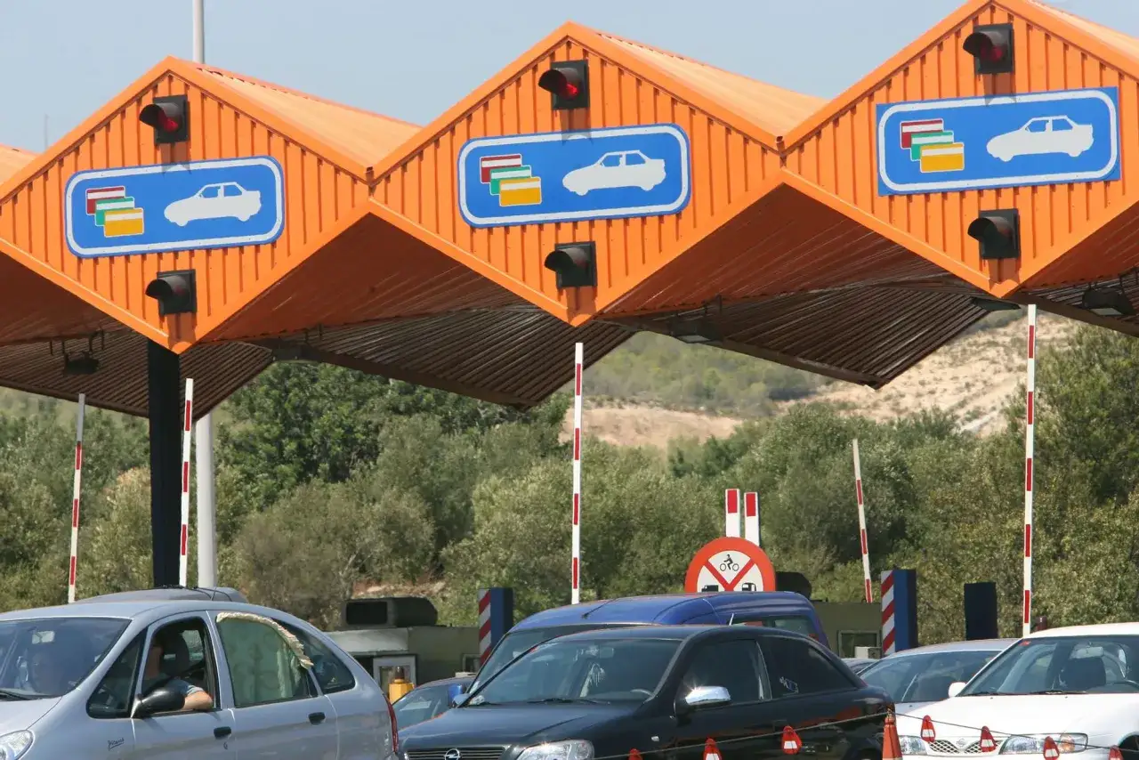 Coches en fila en el peaje de Cubelles. Se&ntilde;ales de tr&aacute;fico y sem&aacute;foros rojos indican que las barreras est&aacute;n cerradas.