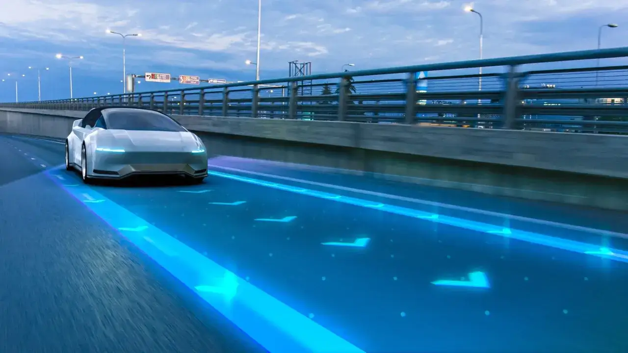 Coche blanco futurista en autopista con luces azules de navegaci&oacute;n, anticipando la tecnolog&iacute;a euro 7.